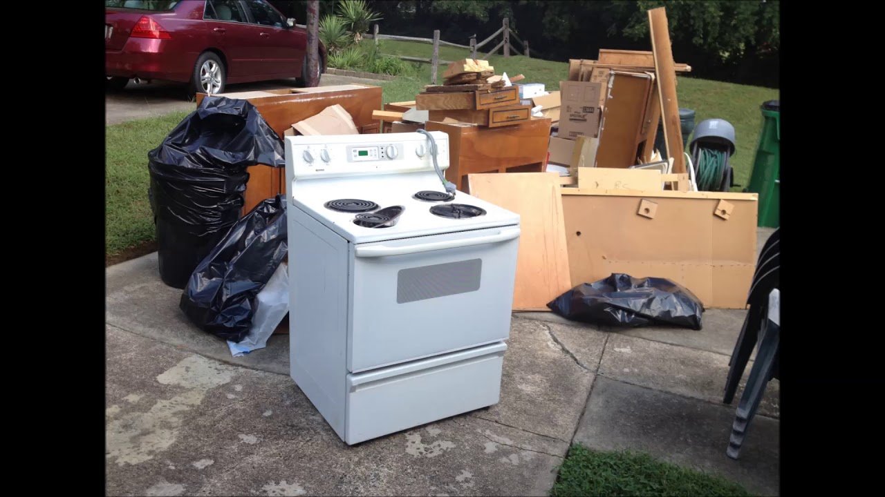 Appliance Removal Services Kent WA showing an old electric stove, furniture, and household junk placed curbside for professional appliance pickup and disposal.